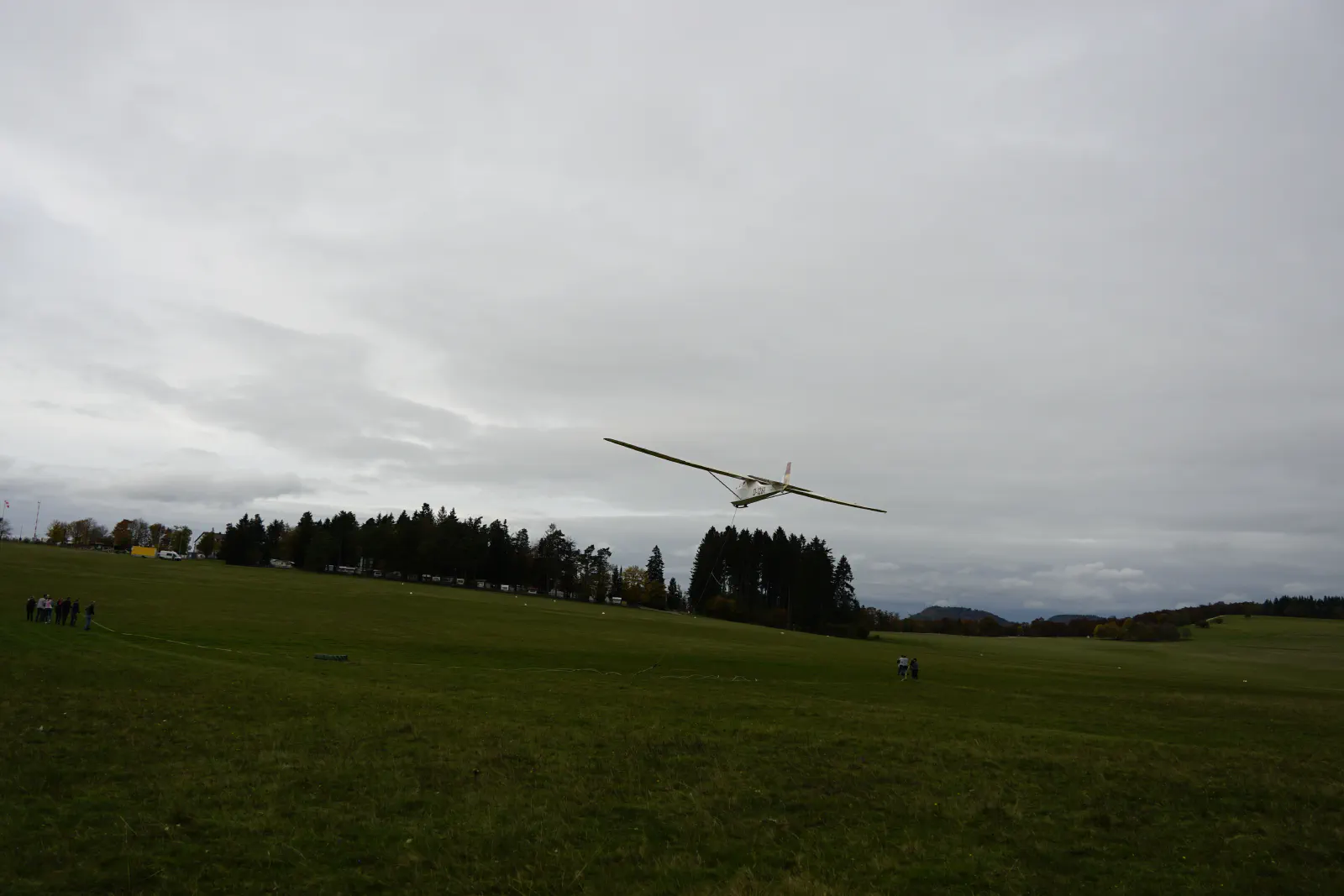 Grunau Baby beim Gummiseilstart, rechts und links sind die Seilmannschaften zu erkennen, welche V-förmig die Gummiseile vor dem Flugzeug straffen